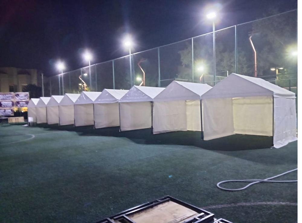 Row of white marquee tents at night