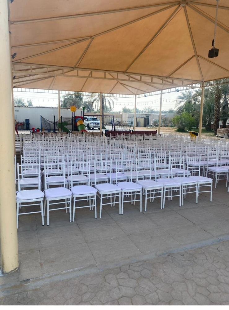 Rows of white chiavari chairs outdoor canopy