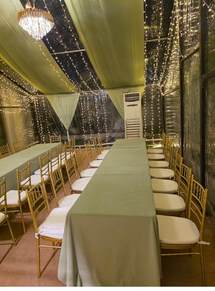 Tent interior with sage green drapery and gold chairs