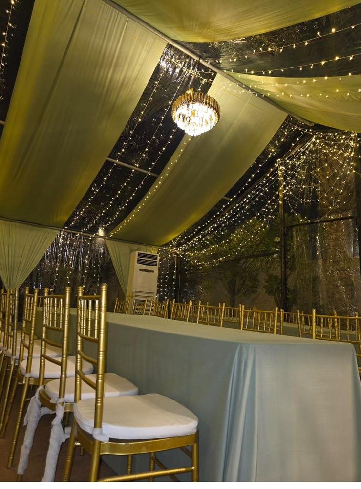 Tent ceiling with string lights and chandelier