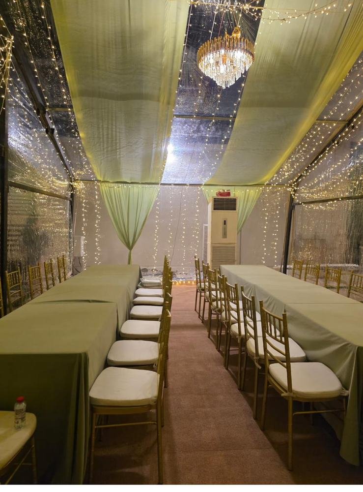 Tent dining setup with sage green table runners