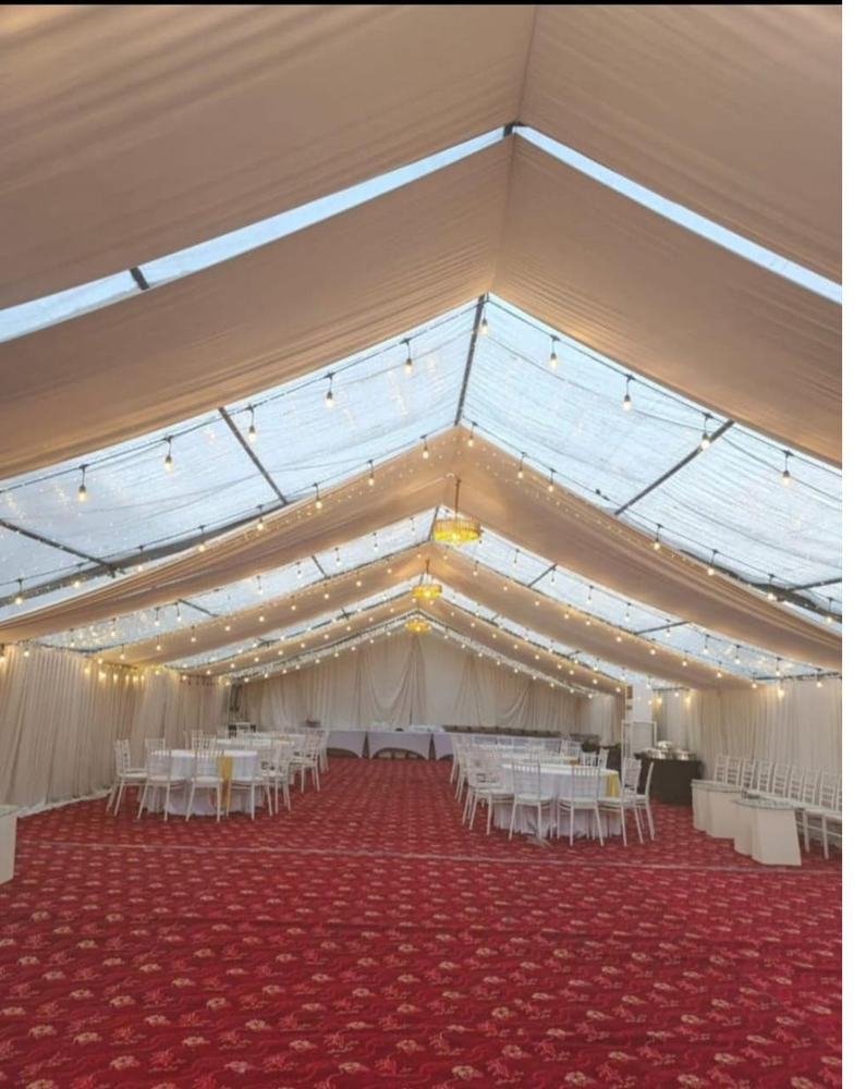 Marquee tent interior with string lighting and red carpet